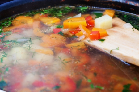 Vegetable soup in a pot with wooden spoonの写真素材