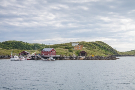 View from a boat of houses and small harbor on island in Northern Norwayの写真素材