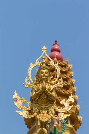 the gold deva statue with worship backgroundの写真素材