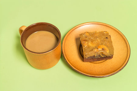 fresh brownie cake with Cashew nuts on surface and a cup of coffeeの写真素材