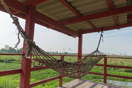 The old hammock with sky and canal for relax timeの写真素材