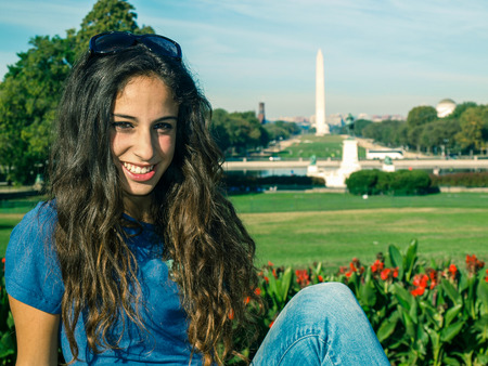 Young girl posing in front of the Ulysses S. Grant Memorial, National Mall and Washington Monument in Washington DC, USAの写真素材