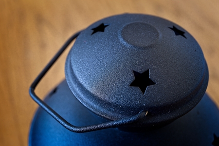 Black metal lampholder with carved stars on a wooden table