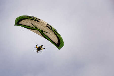 Motorized paraglider flying through the skyの写真素材