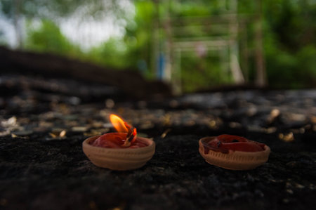 Candle in the shape of a flower on a wooden background.