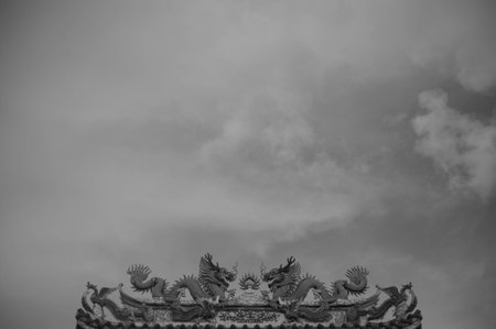 Chinese style dragon statue on the roof of the temple in black and whiteの写真素材