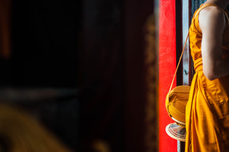 Buddhist monk in traditional clothes standing at the door of the temple.