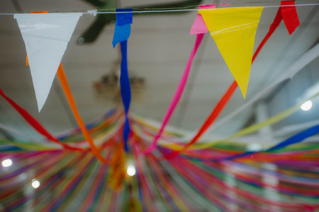 Multicolored paper garland hanging on a rope with blurred background