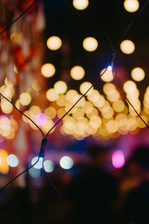 Bokeh background of colorful lights with blurred people in the backgroundの写真素材