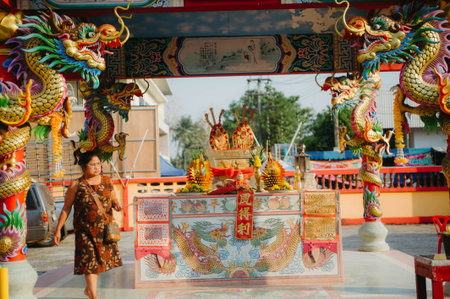 Unidentified asian woman and dragon statue in Chinese temple.のeditorial素材