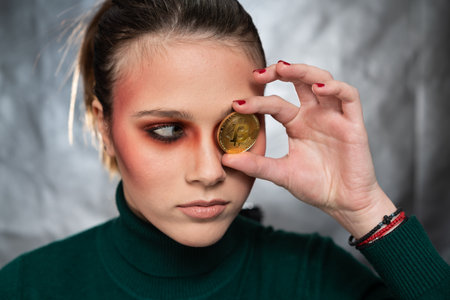 Beautiful woman holding a bitcoin, in different facial expressions, studio shotの写真素材