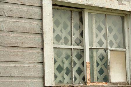 Abandoned wooden barn with broken window and panes