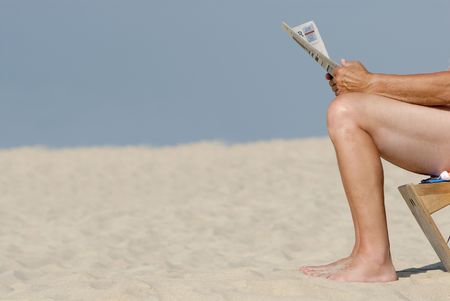 Business man with newspaper at the beachの写真素材