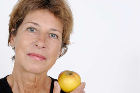 Older woman with an appleの写真素材