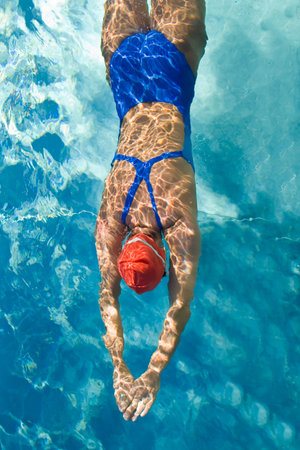 Athletic swimmer is diving in a swimming poolの写真素材