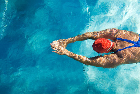 Athletic swimmer is diving in a swimming pool