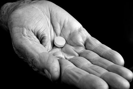 Hand from an old woman with a pill insideの写真素材