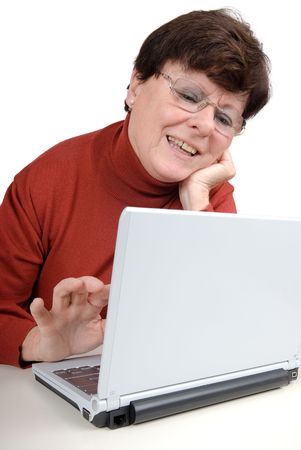 Senior woman in front of a computer. Studio picture. Full isolated.の写真素材
