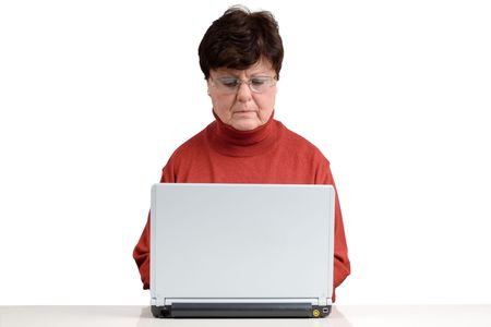 Senior woman in front of a computer. Studio picture. Full isolated.の写真素材