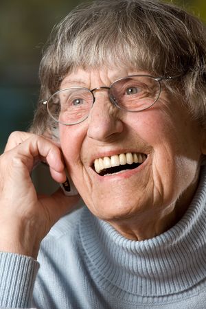 Smiling grandmother (80s) with cellphone. Studio pictureの写真素材