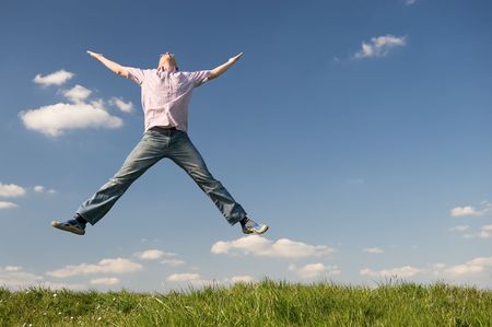 Young man is jumping over a green. Use it for lifestyle conceptsの写真素材