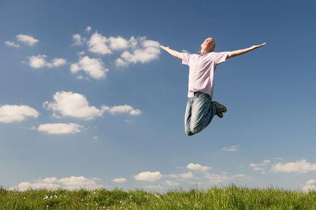 Young man is jumping over a green. Use it for lifesytle conceptsの写真素材