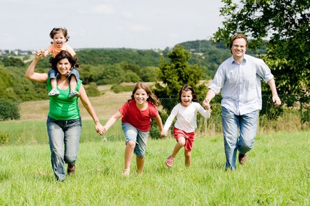 Young family running over a farmer´s fieldの写真素材