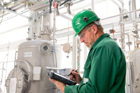 Middle aged industrial worker with notebook Middle aged industrial worker with notebook