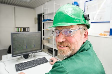Industrial worker in his office in front of a pcの写真素材