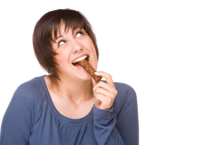 Full isolated portrait of a beautiful caucasian woman eating some sweetsの写真素材