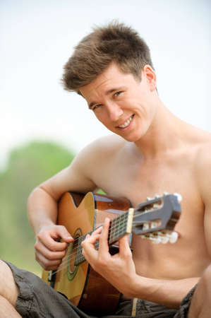 Smiling young man with guitarの写真素材