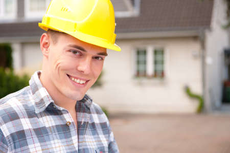 Young architect with plan in front of a building