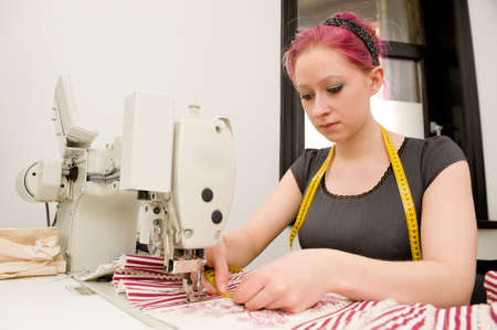 Dressmaker with sewing machine in her studio