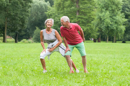 Active senior couple in the park doing gymnasticsの写真素材