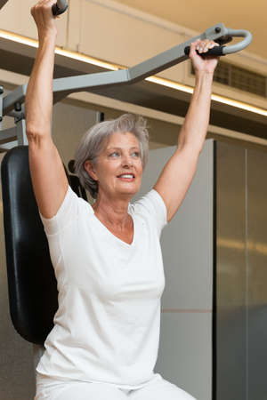 Active and smiling senior in a gym