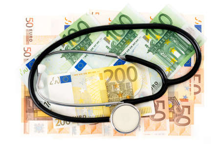 Euro banknotes with stethoskop in front of white backgroundの写真素材