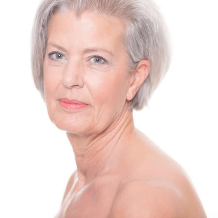 Portrait from a senior woman in front of white backgroundの写真素材