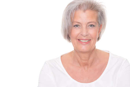 Smiling senior woman in front of white backgroundの写真素材
