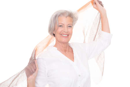 Senior woman with scarf in front of white backgroundの写真素材