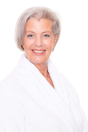 Senior woman with bathrobe in front of white backgroundの写真素材