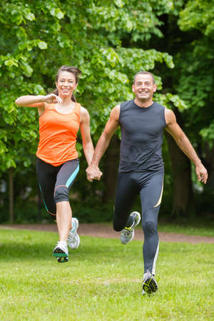 Sport couple in front of green forest