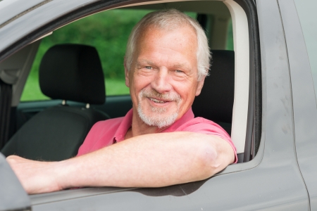 Smiling and happy senior in black car 