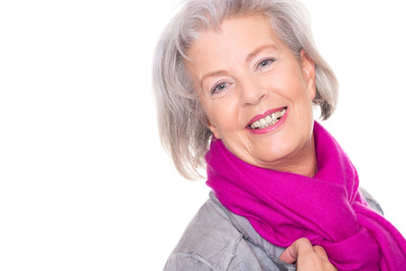 Portrait from a smiling senior woman in front of white backgroundの写真素材
