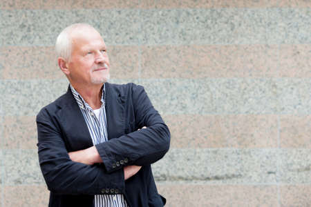 Senior man in front of a wallの写真素材