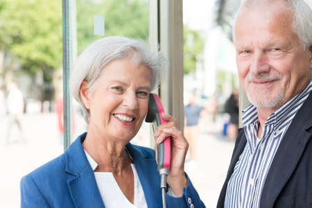 Senior couple call in a phone boxの写真素材