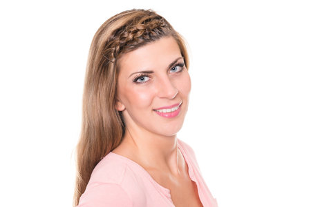 Smiling young woman in front of white backgroundの写真素材