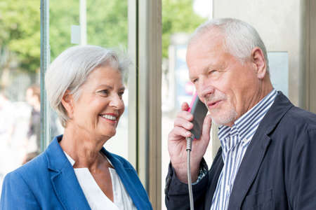 Senior couple call in a phone boxの写真素材