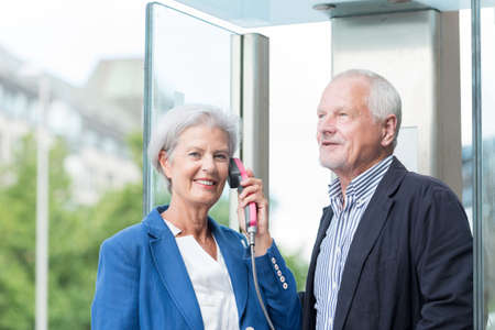 Senior couple call in a phone boxの写真素材