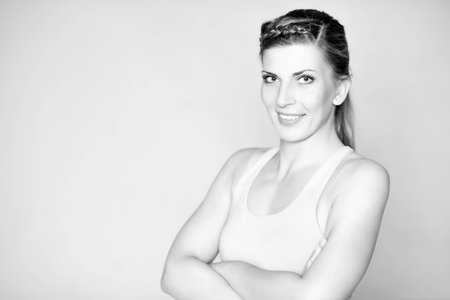 Young and sporty woman in front of grey backgroundの写真素材