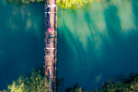 Nice wooden bridge across the green lake in Moc Chau province northern Vietnamの写真素材